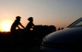 The shadow of car shape and cycling couple at beautiful sunset Royalty Free Stock Photo