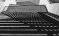 The shadow cast by the railing creates symmetrical patterns on the stairs. Black and white Royalty Free Stock Photo