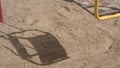 Shadow cast by swing moves on sand following teeterboard