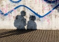 Shadow of couple on city concrete wall with graffiti