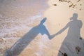 Shadow couple holding hands and Abstract sand of beach and soft wave background