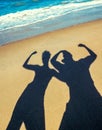 shadow silhouette of a couple of man and girl on a sandy beach near the sea surf Royalty Free Stock Photo