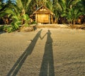 Shadow of a couple on the sunset beach near the bungalow Royalty Free Stock Photo