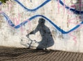 Shadow of man on bicycle on city concrete wall with graffiti Royalty Free Stock Photo