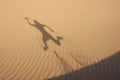 Shadow in dunes with jumping man Royalty Free Stock Photo