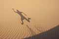 Shadow in dunes with jumping man