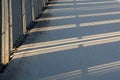 Shadow from the fence on the road on a sunny winter day Royalty Free Stock Photo