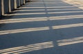 Shadow from the fence on the road on a sunny winter day Royalty Free Stock Photo