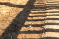 Shadow from a fence on yellow sand on a hot day Royalty Free Stock Photo