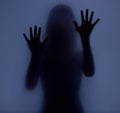 Shadow, glass and hands with a woman in studio on a blue background for mystery or sensual secrecy. Creative, silhouette