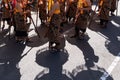 Shadow of the group of Balinese dancer in ethnic costumes with traditional colorful umbrellas on hindu ceremony parade during