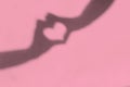 Shadow of hands with heart shape on pink background, love concept Royalty Free Stock Photo