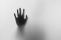 Shadow hands of the Man behind frosted glass.Blurry hand abstraction.Halloween background.Black and white picture Royalty Free Stock Photo