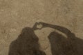Shadow heart formed by hands on a sun sand Royalty Free Stock Photo