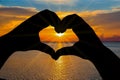 Shadow of the heart-shaped hands clasped with the sunset sky Royalty Free Stock Photo