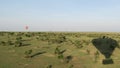 Shadow of hot air balloon over Masai Mara landscape, with a hot air balloon visible in the far distance Royalty Free Stock Photo