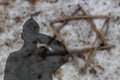 Shadow of an Israeli soldier saluting a gravestone with a Jewish star from branches. Yom Hazikaron, Holocaust