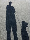 Shadow of Man and Dog Walking Royalty Free Stock Photo