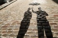 The shadow of a man holding the umbrella above his partner. Royalty Free Stock Photo