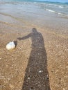 Shadow of a man picking the plastic trash from the beach. The abstract for cleaning and safe the beach. Royalty Free Stock Photo