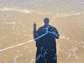 The shadow of a man on the sand during the high tide of the sea wave Royalty Free Stock Photo