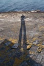 Shadow man in a sea shore rock Royalty Free Stock Photo