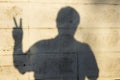 Shadow of man showing two fingers on The wall, a sign of Peace or Victory Royalty Free Stock Photo