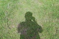 A shadow of a man was taking a camera to take a photo on the green grass in the park Royalty Free Stock Photo
