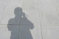 A shadow of a man was taking a camera to take a photo on the pavement in the park Royalty Free Stock Photo