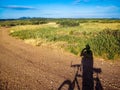 Shadow of a mountain biker on his bike on a dirt road that crosses the nature of Provence at the Orgon plateau in France