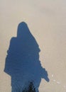 the shadow of a Muslim woman on the sand of the beach Royalty Free Stock Photo