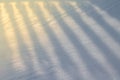 Shadow from an openwork fence, falling on the snow as a background or a backdrop