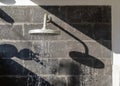 Shadow of an outside shower head on a basalt stone wall, Bali