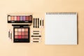 Shadow pallet and applicators with white notepad on yellow background.