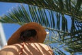 Shadow of palm leaves on back of beautiful woman in hat relaxing at pool. Skin care and sunscreen Royalty Free Stock Photo