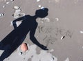 A shadow of a person on a black sand beach displaying the Mandarin characters for the words family and love Royalty Free Stock Photo