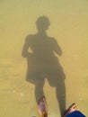 Shadow of a person on sand by the sea Royalty Free Stock Photo