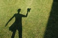 The shadow of the photographer with camera on the lawn at mid summer sunny day