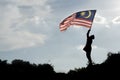 Silhouette of a boy holding the malaysian flag celebrating the Malaysia independence day