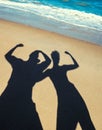 Shadow silhouette of a couple of man and girl on a sandy beach near the sea surf Royalty Free Stock Photo