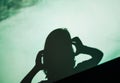 Shadow silhouette of female woman screaming scared holding head with hand