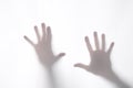 Shadow or silhouette of two man`s hands touching a white fabric from behind  in transparency with copy space for your text Royalty Free Stock Photo
