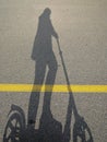 Shadow of a someone riding a scooter on a Sunny day on a bike path Royalty Free Stock Photo