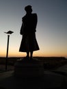 Shadow of a statue of former queen Wilhelmina on the boulevard in Noordwijk during sunset in the Netherlands