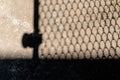 Shadow of steel mesh gate on the cement floor. Royalty Free Stock Photo