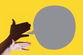 shadow theater. hand shows dog with open a mouth. She's talking on yellow background Royalty Free Stock Photo