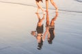 Shadow of two girls holding hands walking by the beach