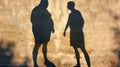 Shadow of two men engaged in conversation against wall Royalty Free Stock Photo