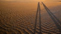 The shadow of a very long couple holding hand on a sand beach surface Royalty Free Stock Photo