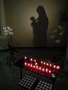 Shadow of Virgin Mary holding her baby with flowers and candles Royalty Free Stock Photo